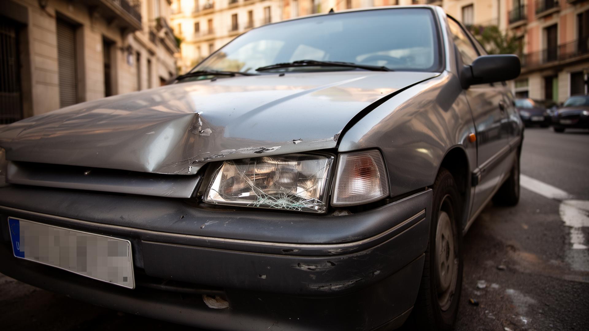 Frontal de coche viejo con bumper hundido y faro roto